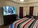 Bedroom with a king bed, large TV, gray sofa and dark wood floors at 1291 Long Acre Dr, Loganville, GA 30052