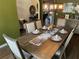 A dining room with modern chandelier hanging over a wooden dining table staged for a formal meal at 1291 Long Acre Dr, Loganville, GA 30052