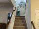 Carpeted staircase featuring wooden handrail and trim with an open view to downstairs rooms at 1291 Long Acre Dr, Loganville, GA 30052