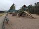 Community playground featuring slides, climbing structures, and shaded seating areas in a wooded setting at 5659 Brookstone Nw Dr, Acworth, GA 30101