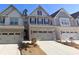 Charming townhome featuring brick accents, a two-car garage, and manicured landscaping at 2059 Lanier Harbor Pt, Buford, GA 30518
