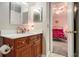 Bathroom with wood cabinets, a decorative mirror and view into an adjacent bedroom at 3979 White Owl Nw Ct, Duluth, GA 30097