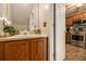 Bathroom featuring a vanity with sink, cabinets, and a view of the kitchen through the doorway at 3979 White Owl Nw Ct, Duluth, GA 30097
