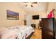 Bright bedroom with a full-sized bed, dark wood dresser, desk, television, and natural light at 3979 White Owl Nw Ct, Duluth, GA 30097