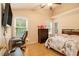 Bright bedroom featuring a full-sized bed, dark wood dresser, desk, and natural light from the window at 3979 White Owl Nw Ct, Duluth, GA 30097