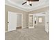 Spacious primary bedroom featuring neutral walls, plush carpet, and a tray ceiling with a modern ceiling fan at 6218 Old Stilesboro Nw Rd, Acworth, GA 30101