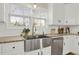 Close-up of kitchen featuring granite counters, white cabinets, stainless sink and modern appliances at 6218 Old Stilesboro Nw Rd, Acworth, GA 30101