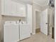 Bright laundry room equipped with modern washer and dryer, built-in cabinets, and tile flooring at 6218 Old Stilesboro Nw Rd, Acworth, GA 30101