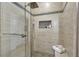 Stylish shower boasts tiled walls with decorative trim, a shower bench, and sleek glass doors at 6218 Old Stilesboro Nw Rd, Acworth, GA 30101