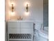 A bathroom vanity area is illuminated by contemporary sconces and features a tile backsplash at 6428 East Cherokee Dr, Canton, GA 30115