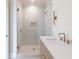 A bathroom vanity area is illuminated by contemporary sconces and features a glass enclosed shower at 6428 East Cherokee Dr, Canton, GA 30115