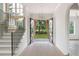 Elegant foyer showcasing an open staircase, modern chandelier, and black steel double front doors at 6428 East Cherokee Dr, Canton, GA 30115
