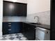 A modern kitchen features black cabinetry, a stainless steel dishwasher, and a marble backsplash at 6428 East Cherokee Dr, Canton, GA 30115