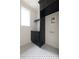 Chic laundry room with black cabinetry, white walls, and black and white patterned floors at 6428 East Cherokee Dr, Canton, GA 30115