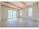 Bright living room with hardwood floors, wood beams, and large sliding glass doors to a balcony at 6428 East Cherokee Dr, Canton, GA 30115