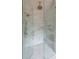 Modern shower with glass door, marble tile, and brass fixtures at 6428 East Cherokee Dr, Canton, GA 30115