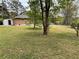 Expansive backyard with green grass and mature trees, with the house visible in the background at 6927 Eunice Dr, Riverdale, GA 30274