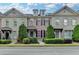 Charming townhome with manicured landscaping, stylish brick facade, and classic architectural details under a partly cloudy blue sky at 7435 Jamestown Dr, Alpharetta, GA 30005