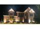 Stunning two-story brick home with elegant architectural details and beautiful landscaping illuminated at night at 125 Forrest Lake Rd, Johns Creek, GA 30022