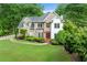 Beautiful front of house with lawn, shrubbery, trees and red doors in a residential neighborhood at 125 Forrest Lake Rd, Johns Creek, GA 30022