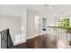 Hallway with wood floors and view of the staircase, bedroom and foliage outside the window at 125 Forrest Lake Rd, Johns Creek, GA 30022