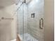 Walk-in shower featuring glass doors, tiled walls, mosaic tile flooring and a recessed shower caddy at 125 Forrest Lake Rd, Johns Creek, GA 30022