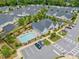 An aerial view showcases a community pool and clubhouse surrounded by charming residential homes with lush landscaping at 306 Cherokee Station Cir, Woodstock, GA 30188