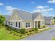 A well-manicured home exterior showcases tan siding, a stone foundation, and a neatly paved driveway at 306 Cherokee Station Cir, Woodstock, GA 30188