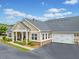 A well-maintained home exterior showcases tan siding, a stone foundation, and an attached two-car garage at 306 Cherokee Station Cir, Woodstock, GA 30188