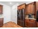A kitchen with stainless steel refrigerator, brown cabinets, and hardwood flooring at 306 Cherokee Station Cir, Woodstock, GA 30188