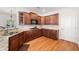 Spacious kitchen featuring granite countertops, wood cabinetry, and hardwood floors at 306 Cherokee Station Cir, Woodstock, GA 30188