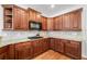 A kitchen featuring brown cabinets, granite countertops, and modern appliances at 306 Cherokee Station Cir, Woodstock, GA 30188