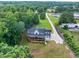 Aerial view of a farmhouse-style home on expansive acreage, featuring a long driveway and lush greenery at 3180 Lee Dr, Buford, GA 30518