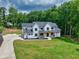 Aerial view of a modern farmhouse with a long driveway, lush lawn, basketball court, and mature trees at 3180 Lee Dr, Buford, GA 30518