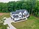 An aerial view of the modern farmhouse with a large yard, a private driveway and a three-car garage at 3180 Lee Dr, Buford, GA 30518