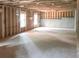 Unfinished basement with concrete foundation, wood framing, and natural light from two windows at 3180 Lee Dr, Buford, GA 30518