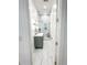 Hallway view of a bathroom featuring marble tiling, a glass enclosed shower with a bench, and a modern vanity at 3180 Lee Dr, Buford, GA 30518