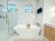 Spa-like bathroom boasting a modern tub with gold fixtures, and a seamless glass shower at 3180 Lee Dr, Buford, GA 30518