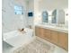 Bright bathroom featuring marble walls, a soaking tub, and double vanities with gold fixtures at 3180 Lee Dr, Buford, GA 30518
