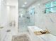 Elegant bathroom with a glass shower, soaking tub, and sleek marble tile design at 3180 Lee Dr, Buford, GA 30518