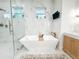 Modern bathroom features a freestanding tub, a separate shower with rainfall shower head, and dual sink at 3180 Lee Dr, Buford, GA 30518