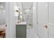 Modern bathroom with stone floors, green cabinets and a glass enclosed shower with gold accents at 3180 Lee Dr, Buford, GA 30518