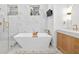 Bright bathroom with a freestanding tub, glass-enclosed shower, marble accents, and modern fixtures at 3180 Lee Dr, Buford, GA 30518
