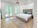 Serene main bedroom with a tufted headboard, natural light, and access to a private balcony at 3180 Lee Dr, Buford, GA 30518