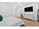 Bright bedroom with a large TV, white dresser, and plush bedding on wood floors at 3180 Lee Dr, Buford, GA 30518