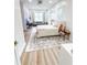 Bright bedroom featuring wood floors, a gray sofa, a gray and white patterned rug and a desk with a mirror at 3180 Lee Dr, Buford, GA 30518