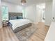 Bright bedroom with a large bed, wood floors, and views of the luxurious Primary bath at 3180 Lee Dr, Buford, GA 30518