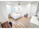 Bright bedroom with light wood floors, natural light, closet, and ceiling fan at 3180 Lee Dr, Buford, GA 30518