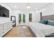 Bright bedroom with french doors and a tufted headboard, natural light, and a stylish decorative rug at 3180 Lee Dr, Buford, GA 30518