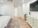 Airy bedroom showcasing a large dresser, wood floors, and a glimpse into the Primary bathroom at 3180 Lee Dr, Buford, GA 30518